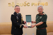 Thượng tướng Nguyễn Chí Vịnh (phải) trao quà lưu niệm  tặng Đại tá Tôn Thất Tuấn (Ảnh: qdnd.vn)